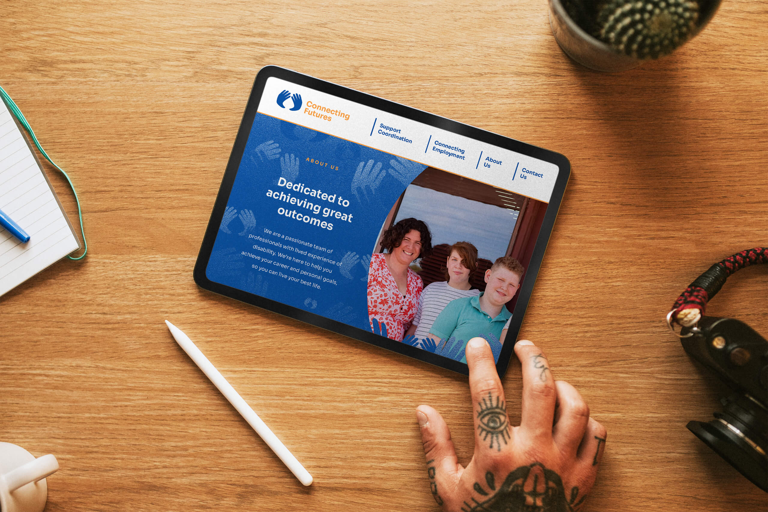 iPad on Table with tattooed hand using Connecting Futures custom website