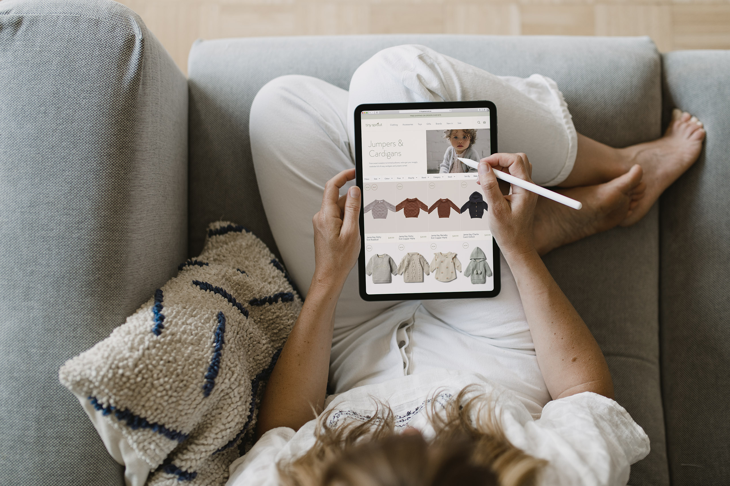 Mockup of Tiny Sprout custom Shopify design on iPad in woman's lap